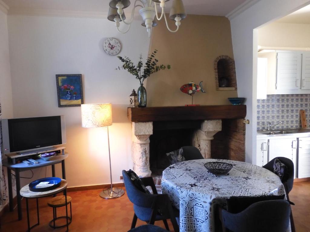 ein Wohnzimmer mit einem Tisch und einem Kamin in der Unterkunft LA GOELETTE et son jardin clos sans parking privé in Étretat