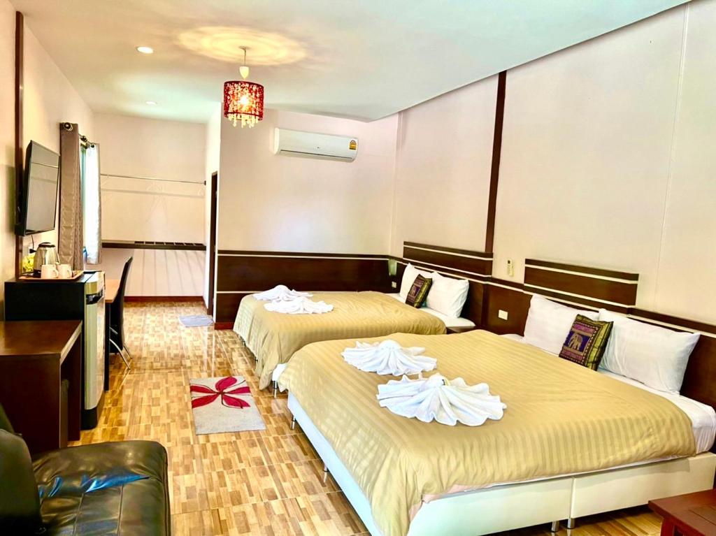 pokój hotelowy z 2 łóżkami i telewizorem w obiekcie Banana Place Resort w mieście Chumphon