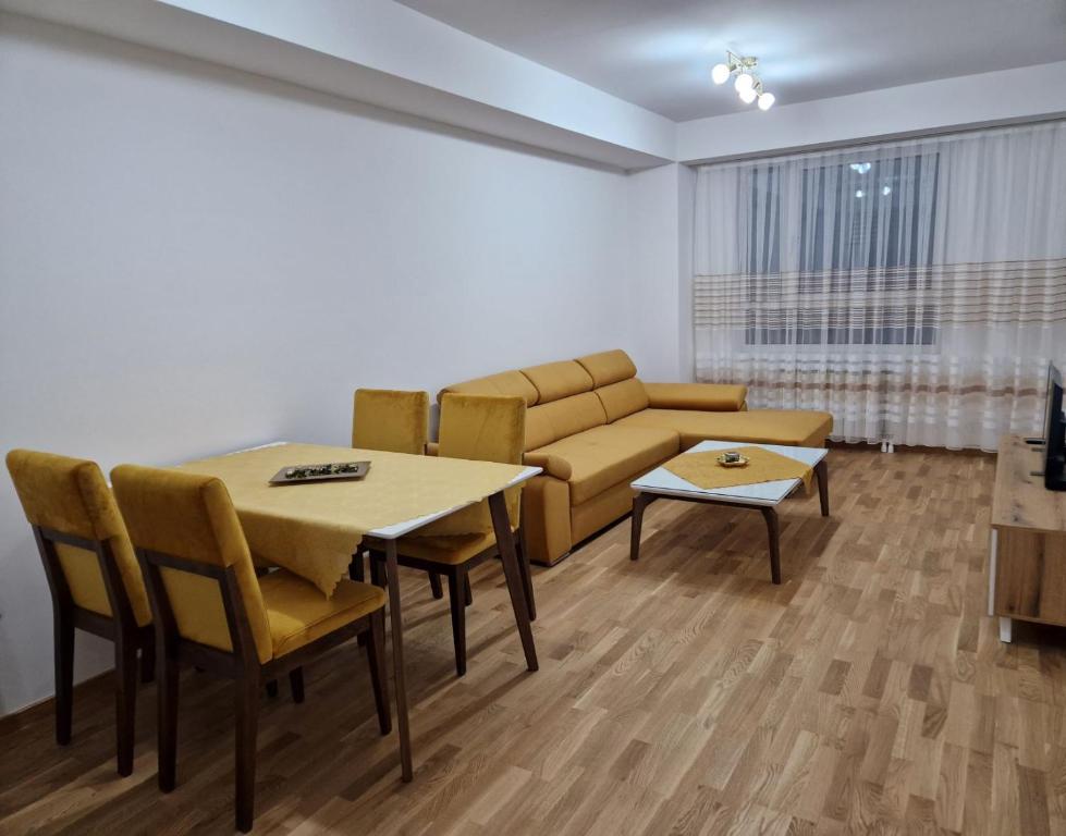 - un salon avec un canapé, une table et des chaises dans l'établissement The Apartment, à Skopje