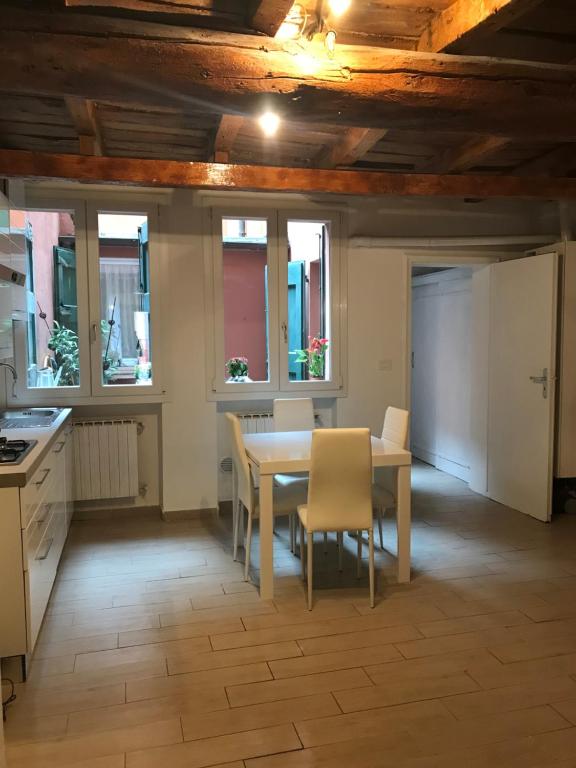 a kitchen with a table and chairs and windows at Casa Gioia Centro Storico in Bologna