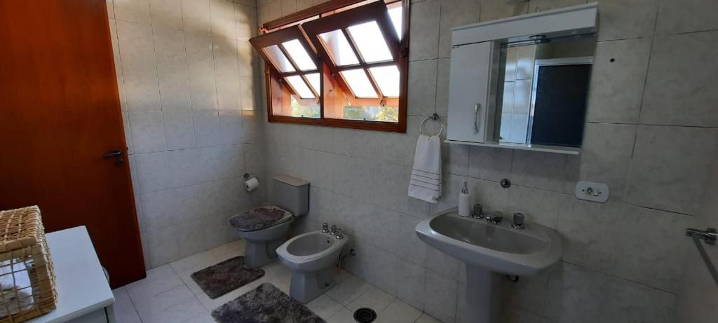 a bathroom with a toilet and a sink at Apartamento em Campos do Jordão próximo ao Capivari in Campos do Jordão