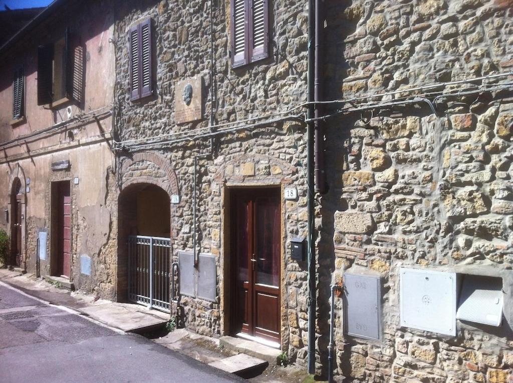 - un bâtiment en pierre avec deux portes dans une rue dans l'établissement La Ramaccia: relax a Montescudaio, à Montescudaio