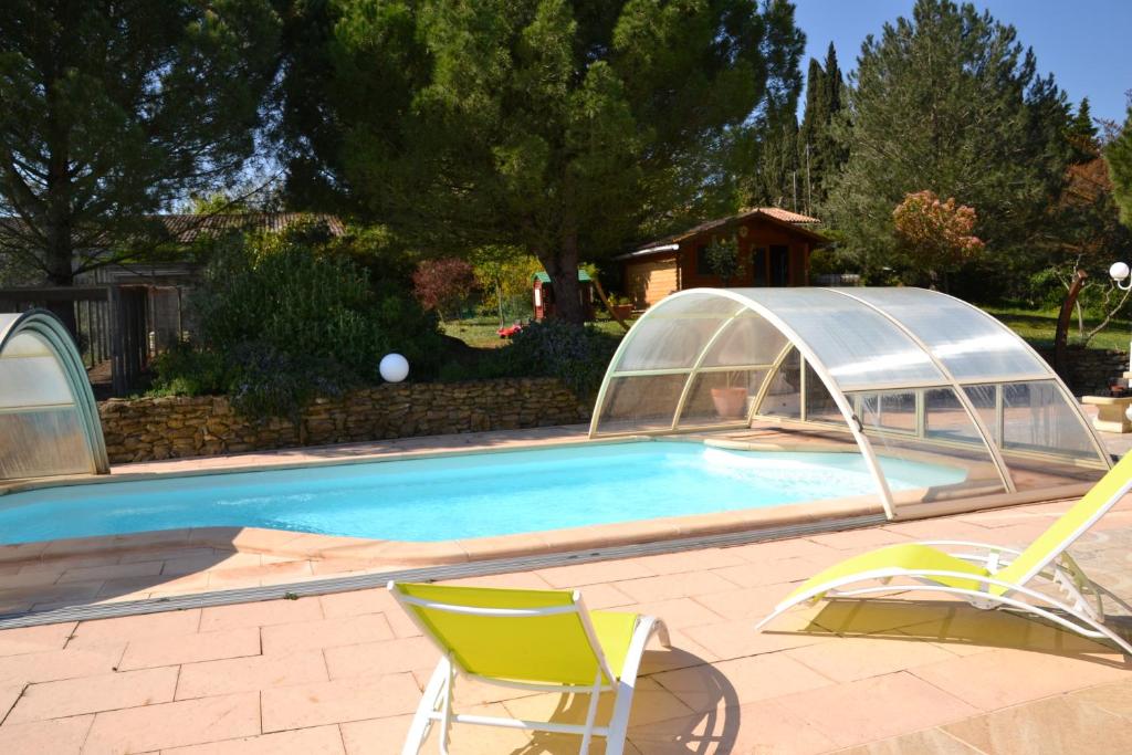 una piscina con una tienda y 2 sillas junto a ella en Au jardin des gallinettes location villa piscine privée Carcassonne, en Alairac