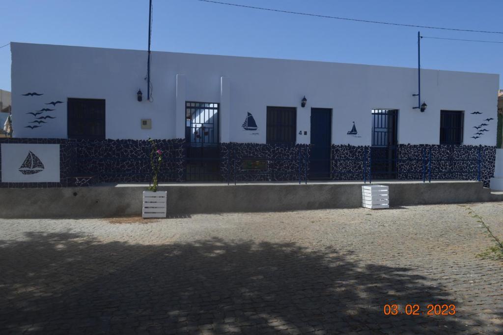 a building with a fence with doors on it at LA VELA in Palmeira