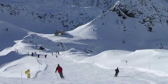 a group of people skiing down a snow covered mountain at lo Miete di Nonni in Champoluc