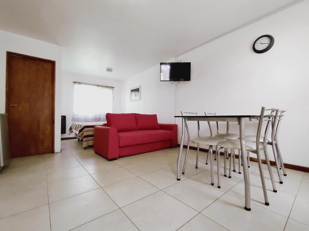 uma sala de estar com um sofá vermelho e uma mesa em Ushuaia bella em Martín Fierro