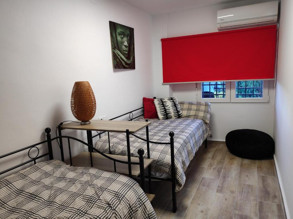a room with two beds and a red curtain at Lille en Provence in Valencia