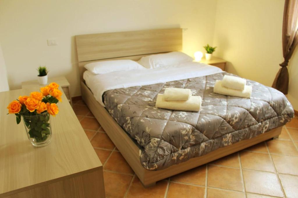 a bedroom with a bed and a table with towels on it at Kyma Flat in Nebida