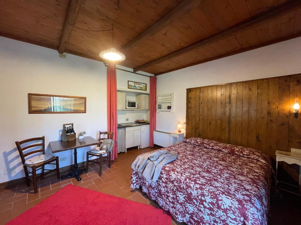 - une chambre avec un lit, un bureau et une table dans l'établissement Agriturismo Biologico Poggiopiano, à Fiesole