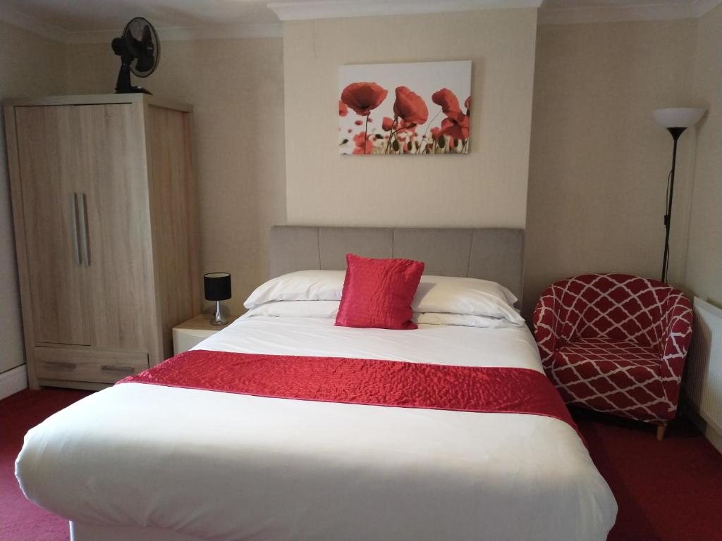 a bedroom with a large white bed with a red blanket at Llanina Arms in Llanarth