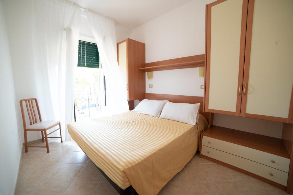 a bedroom with a bed with a cabinet and a window at Residence L'Africhetta in Rodi Garganico