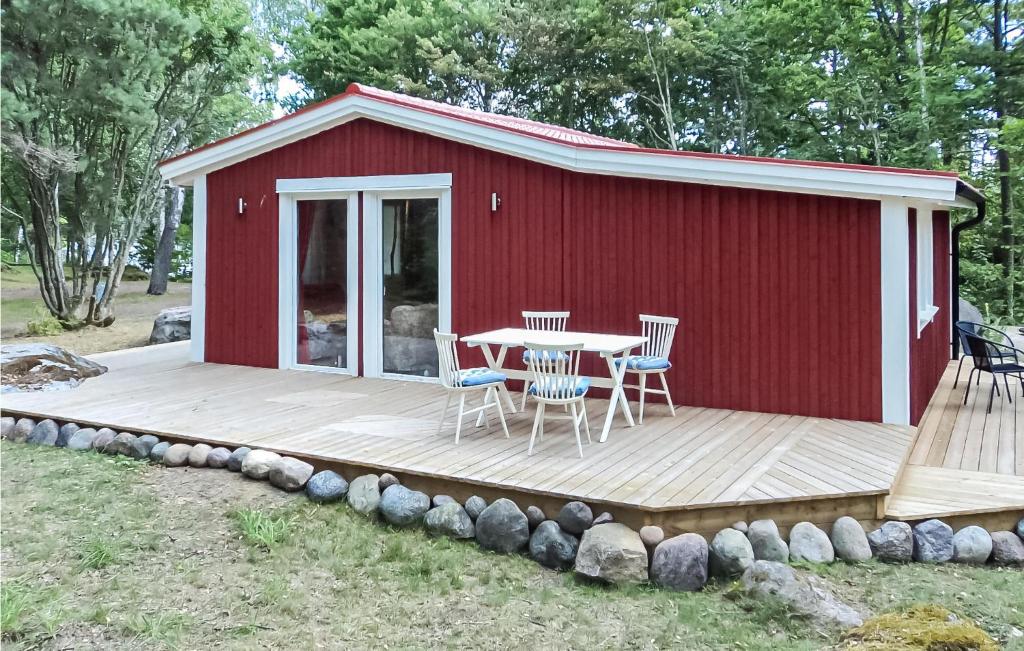 un cobertizo rojo con una mesa y sillas en una terraza en Beautiful Home In Jrnforsen With Lake View, en Järnforsen