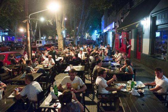 un grupo de personas sentadas en mesas en un restaurante al aire libre por la noche en OLASCOAGA DOS monoambiente en Mendoza