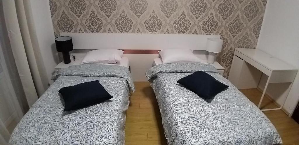 two beds in a room with two pillows on them at Domum Universitate Dalles - Intercontinental in Bucharest