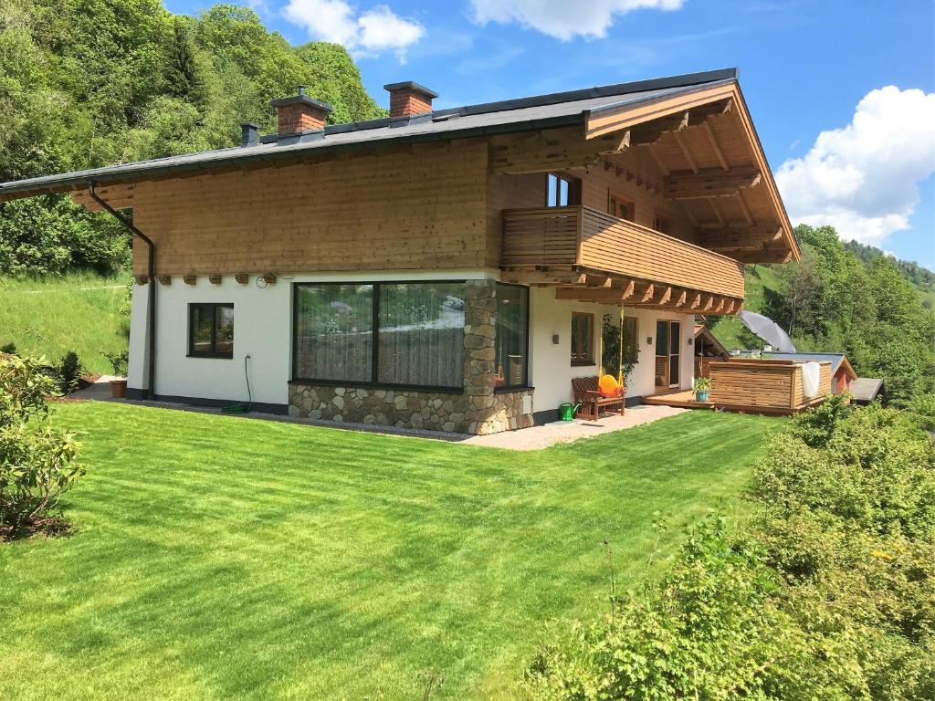 a house with a large lawn in front of it at Landhaus Klausner in Saalbach Hinterglemm