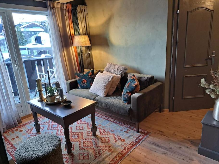 sala de estar con sofá y mesa en Nydelig utsikt, hotell-følelse en Beitostøl