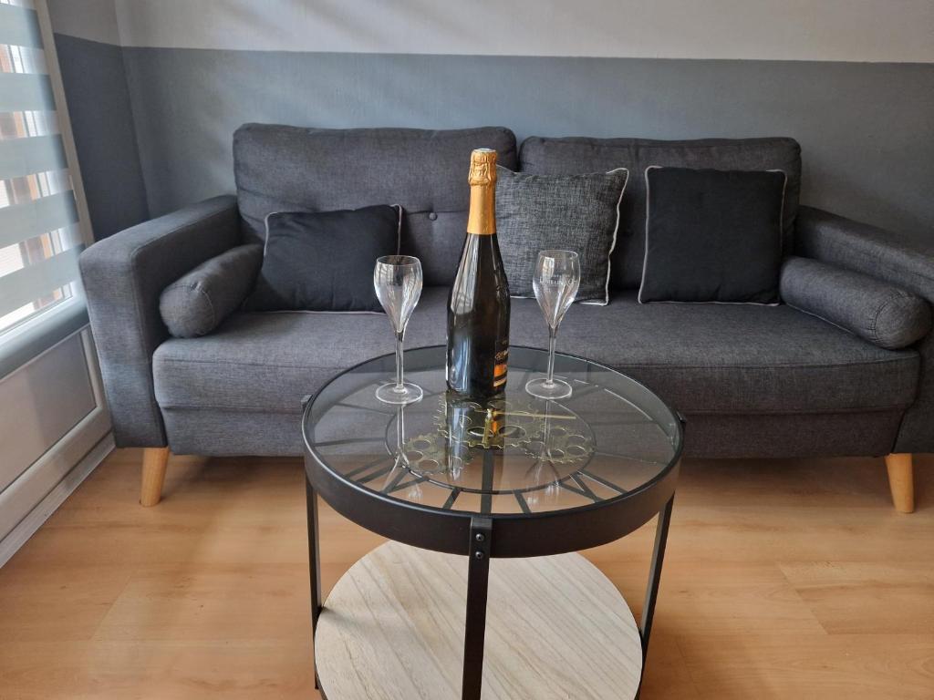 - une bouteille de champagne et 2 verres à vin sur une table dans l'établissement Au cœur du champagne logement privatif (70 m2), à Épernay