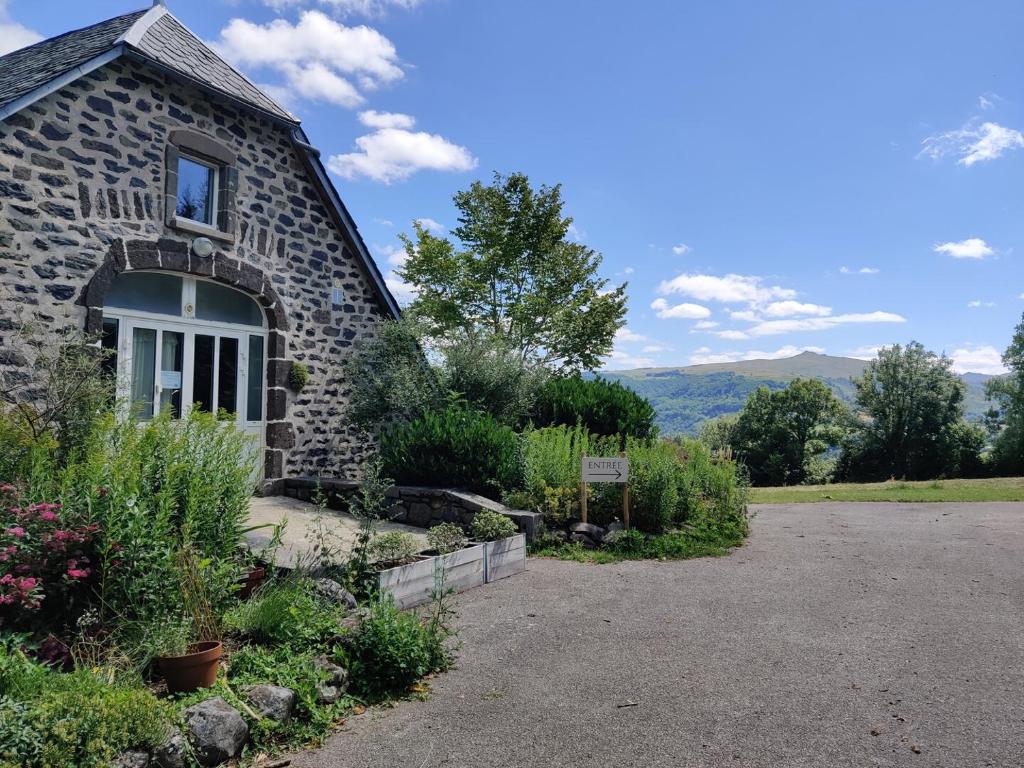 uma casa de pedra com uma janela ao lado em Maison d'Hôtes La Grange em Salers