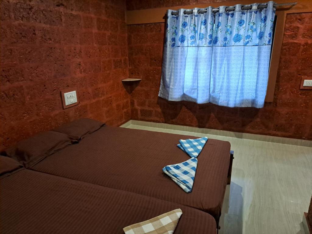 a bed in a room with a window and a couch at Palm Beach Resort in Kumta