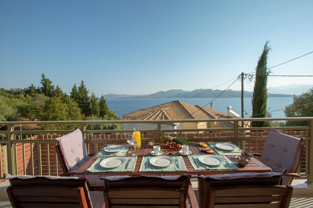 - une table avec des assiettes de nourriture sur le balcon dans l'établissement Nikolas Guest House Villa, à Nikiana