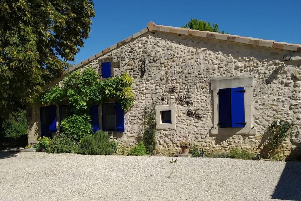 a stone house with blue shutters on it at La maison bleue in Grane