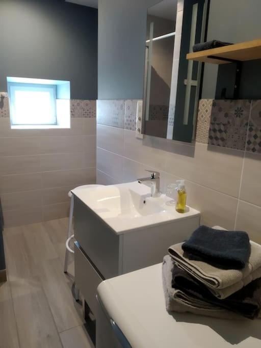 a white bathroom with a sink and a mirror at La maison bleue in Grane