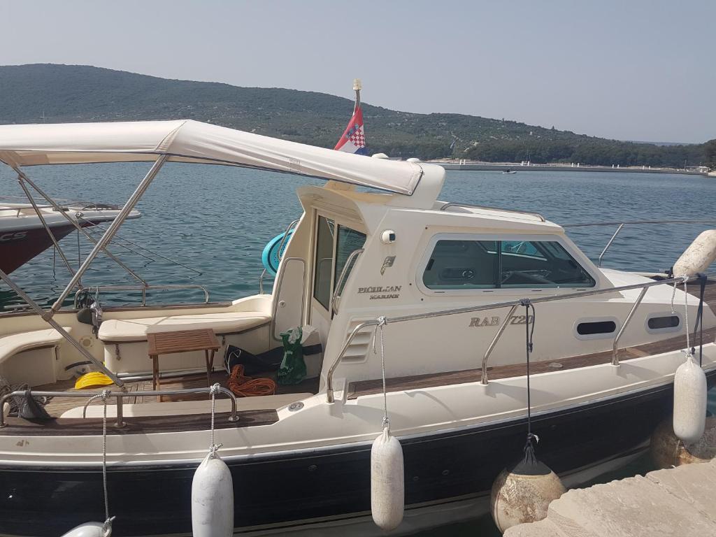 ein weißes Boot ist im Wasser angedockt in der Unterkunft CAPITANO di CHERSO VIP holidays, gourmet & sail experience in Dragozetići