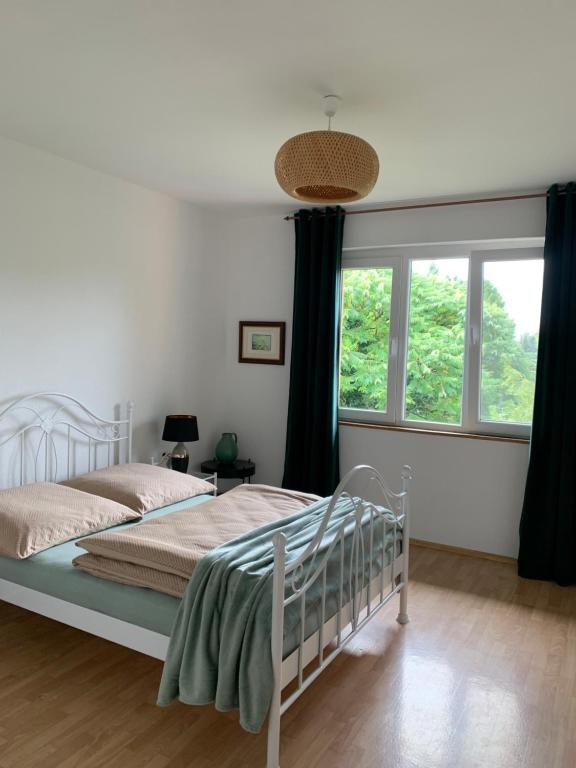 - une chambre avec un lit blanc et une fenêtre dans l'établissement Apartament Blumenblick, à Rielasingen-Worblingen