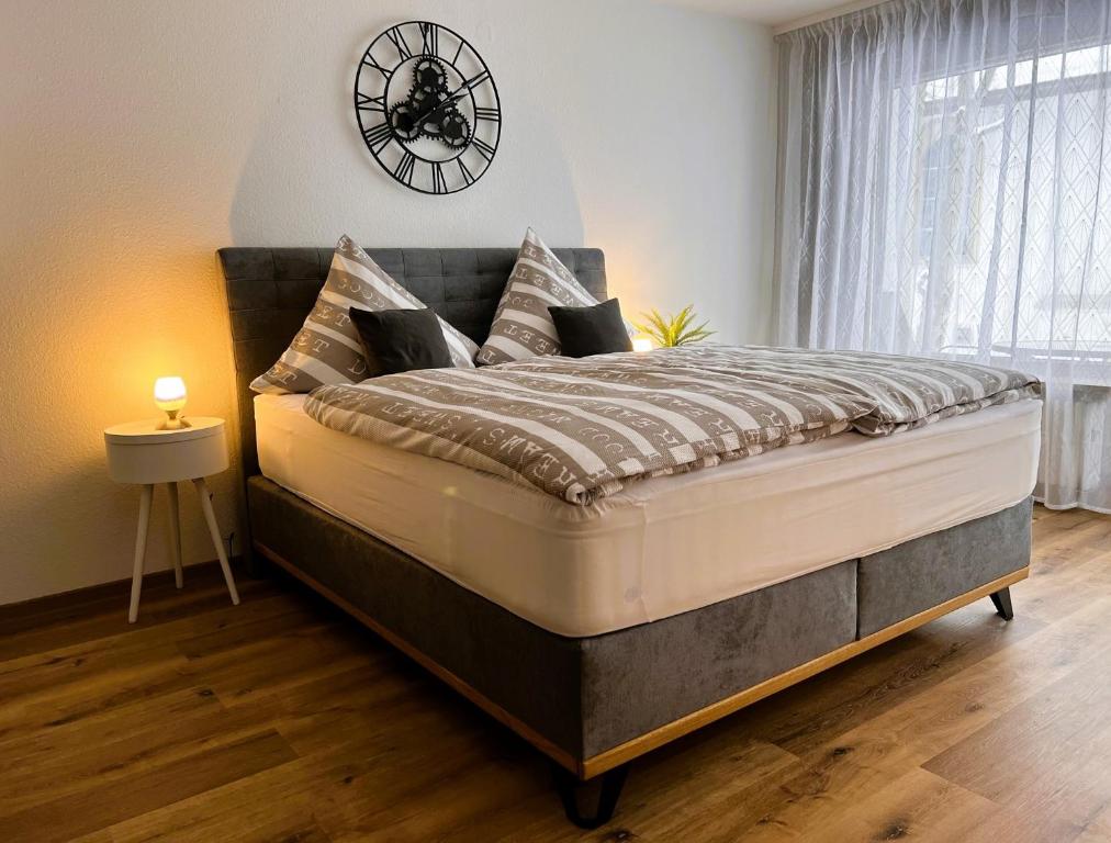 um quarto com uma cama grande e um relógio na parede em Ferienwohnung Traumwerk Titisee em Titisee-Neustadt
