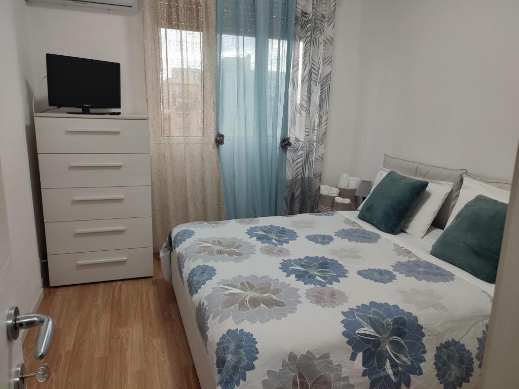 a bedroom with a bed and a dresser with a television at ETRA Casa Vacanza in Taranto