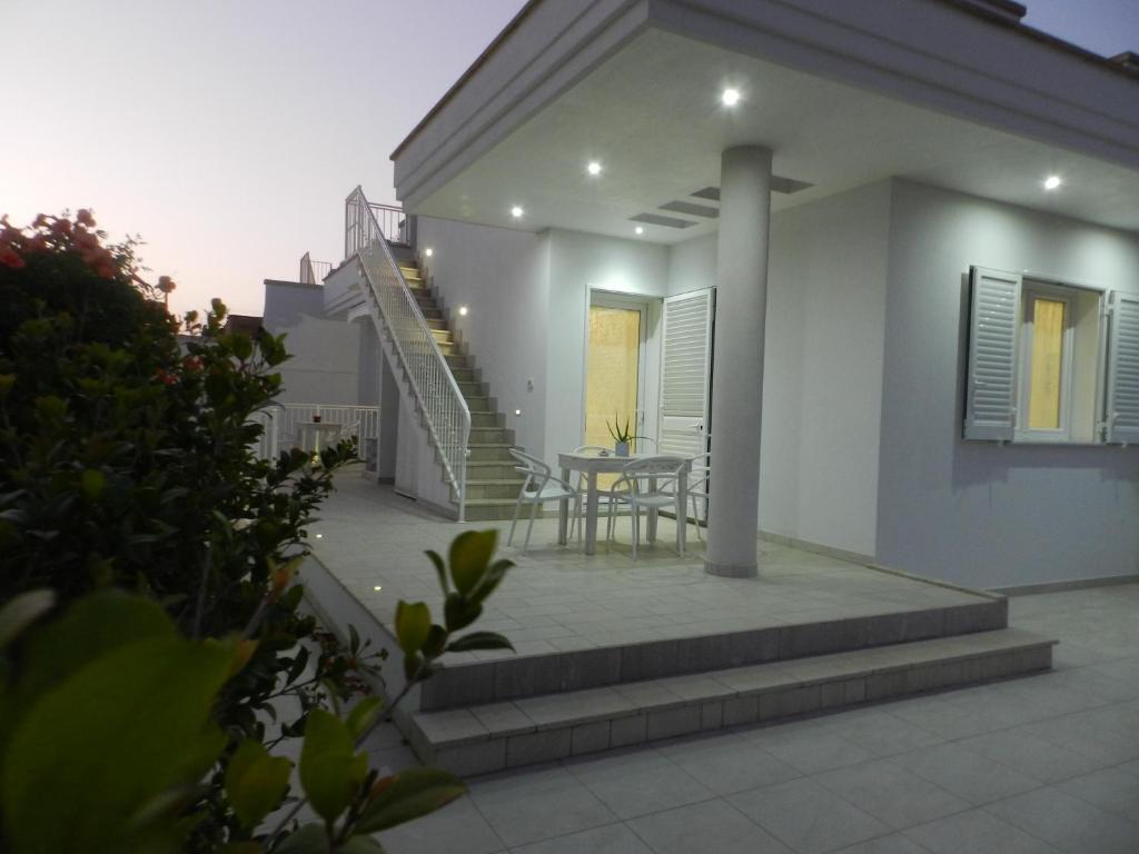 Cette maison dispose d'une terrasse avec une table et des escaliers. dans l'établissement A Pochi Metri Dal Mare, à Marina di Mancaversa