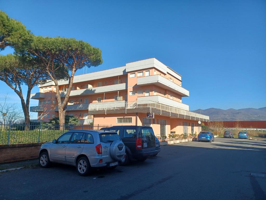 Luni的住宿－appartamento mare di Luni Mare，两辆汽车停在大楼前的停车场
