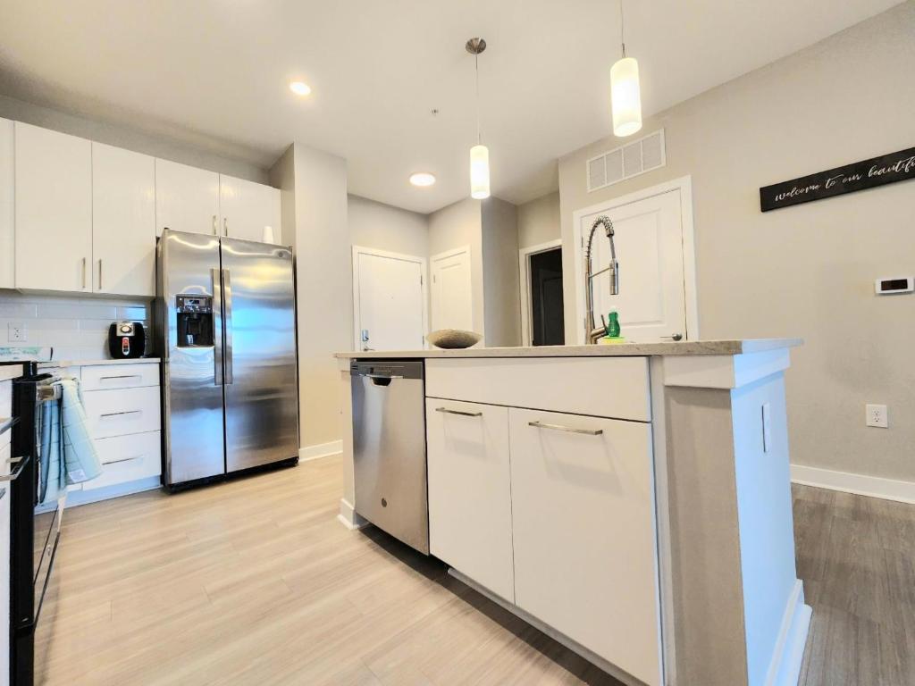 a kitchen with white cabinets and a stainless steel refrigerator at Short term rental in Charlotte