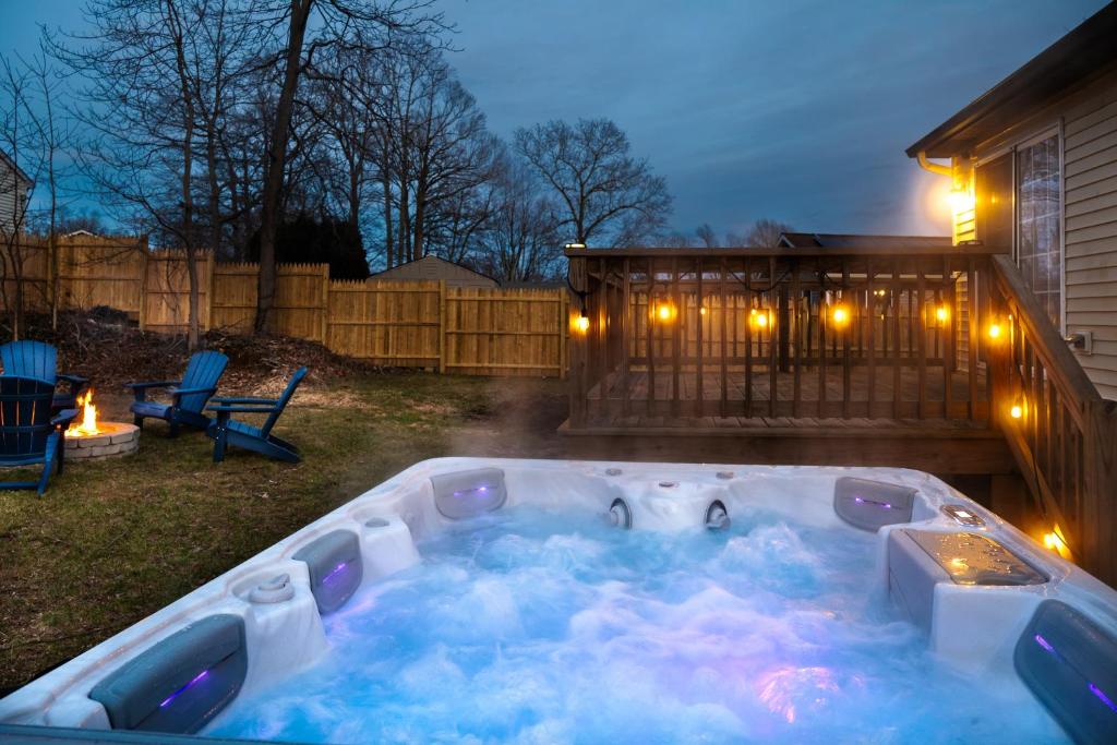 NEW! Updated Mystic Home w/ Sauna, Hot Tub & Deck في ميستيك: جاكوزي في الفناء الخلفي في الليل