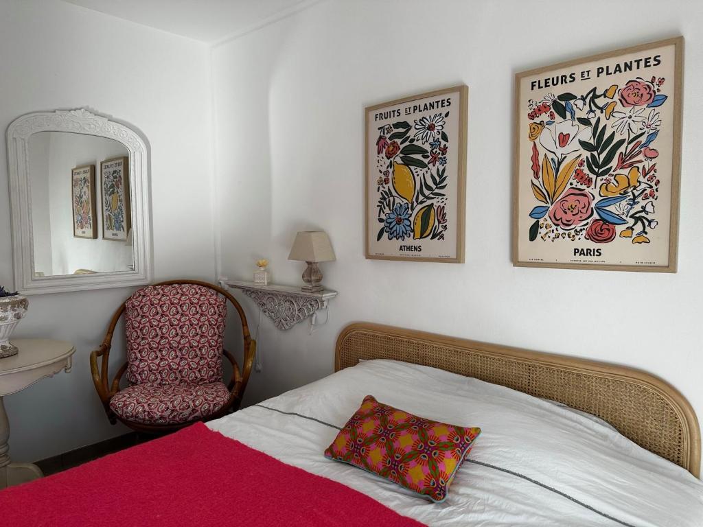 een slaapkamer met een bed, een stoel en een spiegel bij Bel appartement dans le centre ville de Cavalaire in Cavalaire-sur-Mer