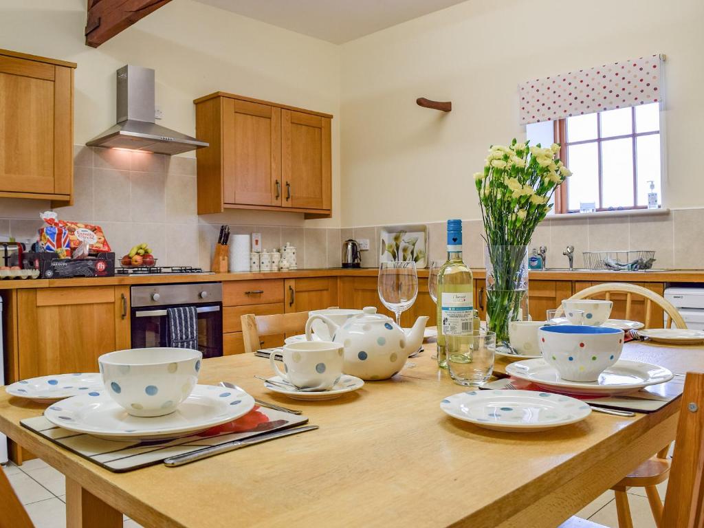 a kitchen with a wooden table with dishes on it at Dragonfly - Uk42521 in Aldwincle Saint Peter