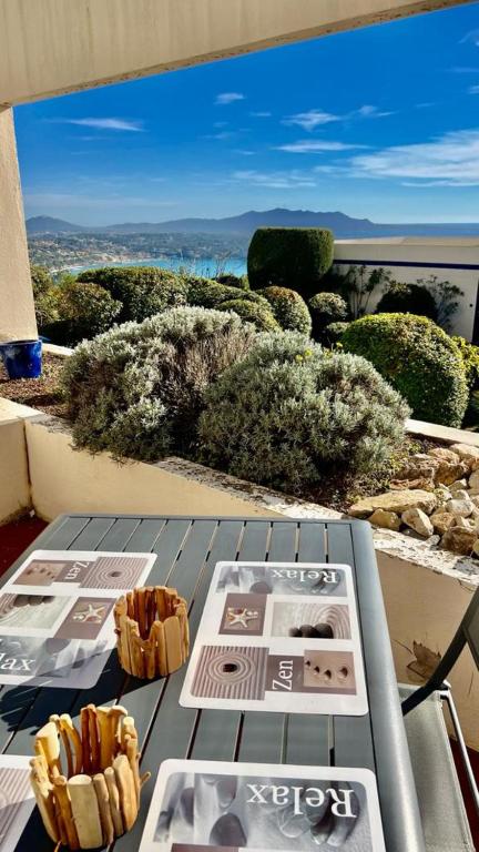 une table avec deux assiettes de nourriture sur un balcon dans l'établissement Résidence Katikias - vue mer, à Bandol