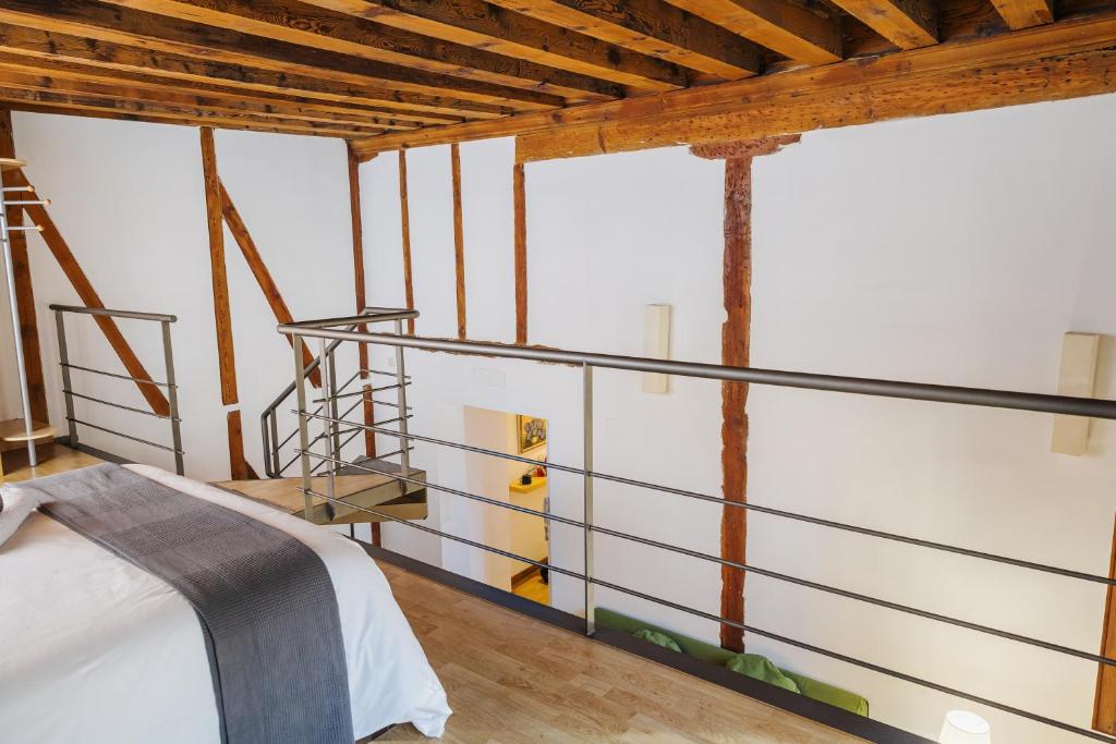 - une chambre avec des murs blancs et des plafonds en bois dans l'établissement APARTAMENTO SANTA CLARA, à Tolède