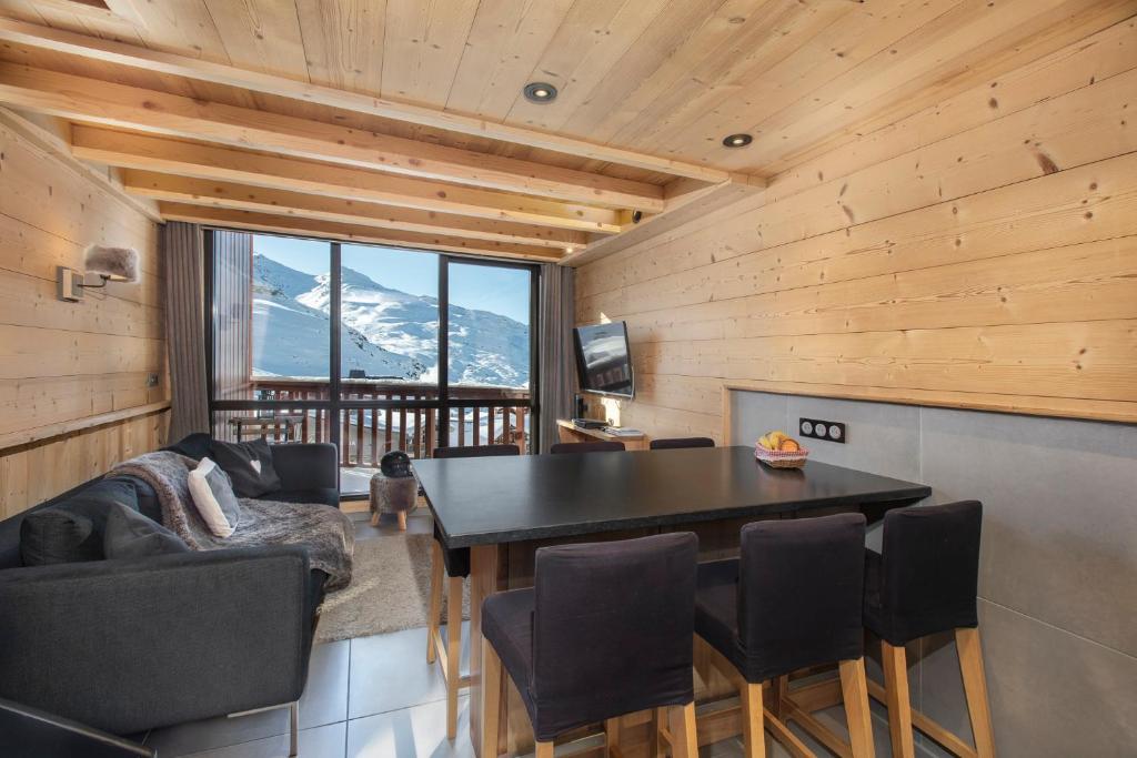 ヴァル・トランスにあるVal Thorens - Cosy Duplex avec Vue Silveralp 338のテーブルと椅子が備わる客室で、山の景色を望めます。