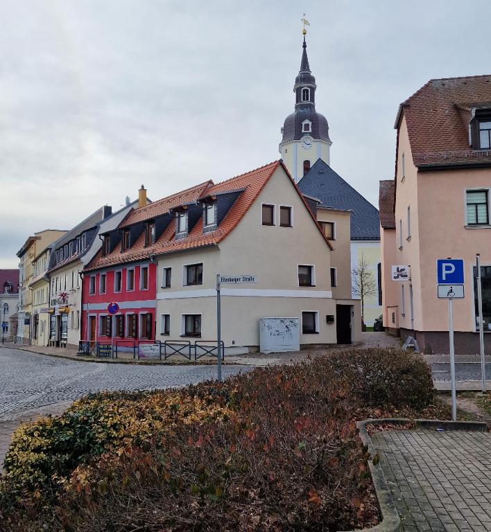 a row of buildings with a church in the background at Ferienhaus Polly in Taucha