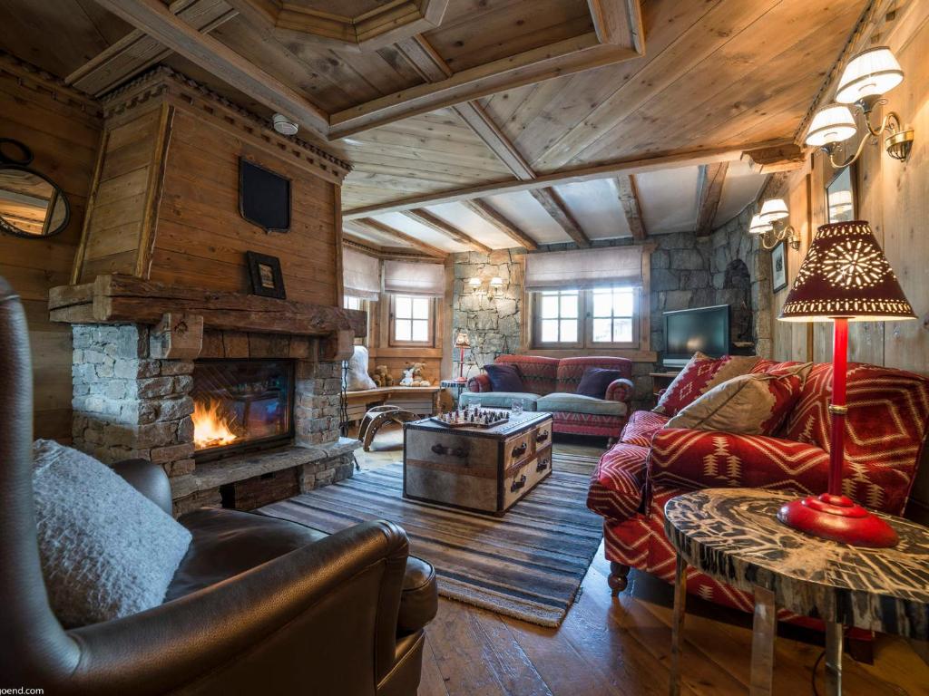 ein Wohnzimmer mit einem Steinkamin in einem Haus in der Unterkunft Duplex de Charme à Courchevel 1850 - Capacité 10 Personnes, Centre-Ville - FR-1-575-29 in Courchevel