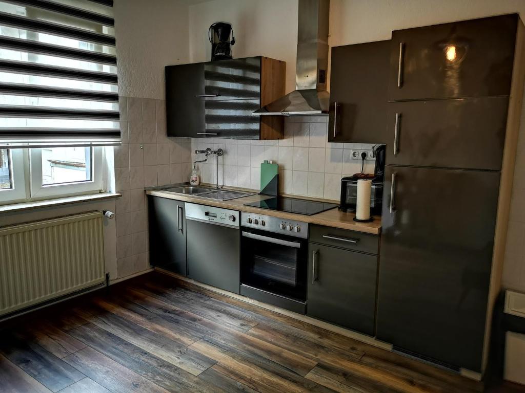 POLAT Apartments 3 في إيسن: مطبخ مع أجهزة ستانلس ستيل وأرضيات خشبية