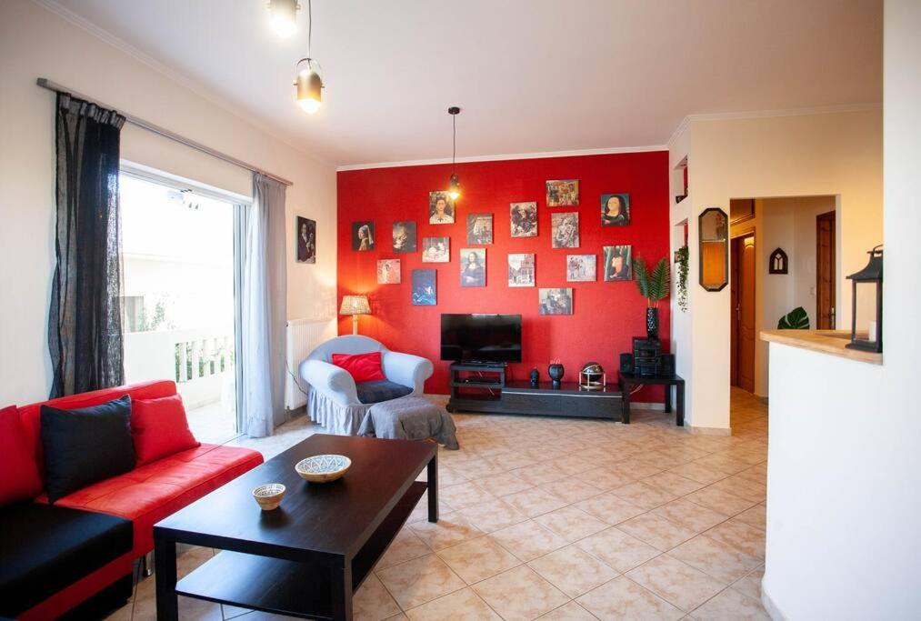 sala de estar con pared de acento rojo en Retro seaside resort en La Canea