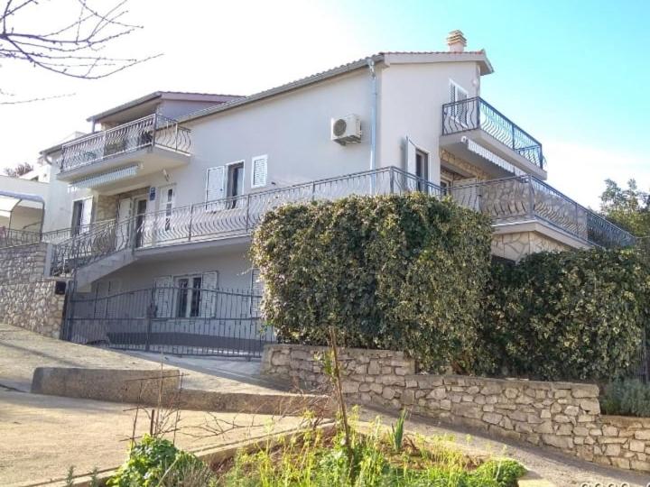 un gran edificio blanco con balcones y una pared de piedra. en Apartment Ivona, en Stomorska