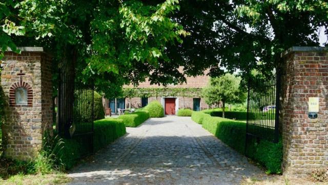 a gate to a brick building with a driveway at B&B De Hulst in Izegem