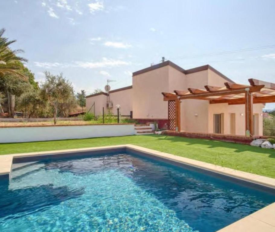 une villa avec une piscine en face d'une maison dans l'établissement Villa Laura, à Cefalù