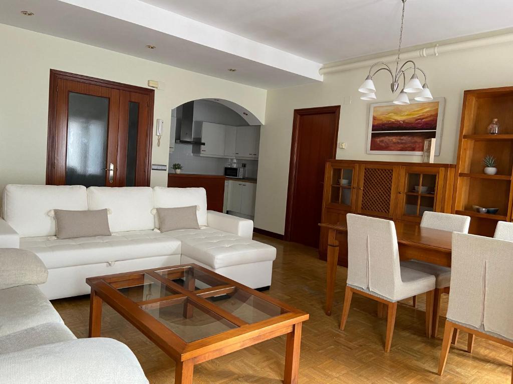 a living room with a white couch and a table at KAIOA .Incluye parking privado. in Hondarribia