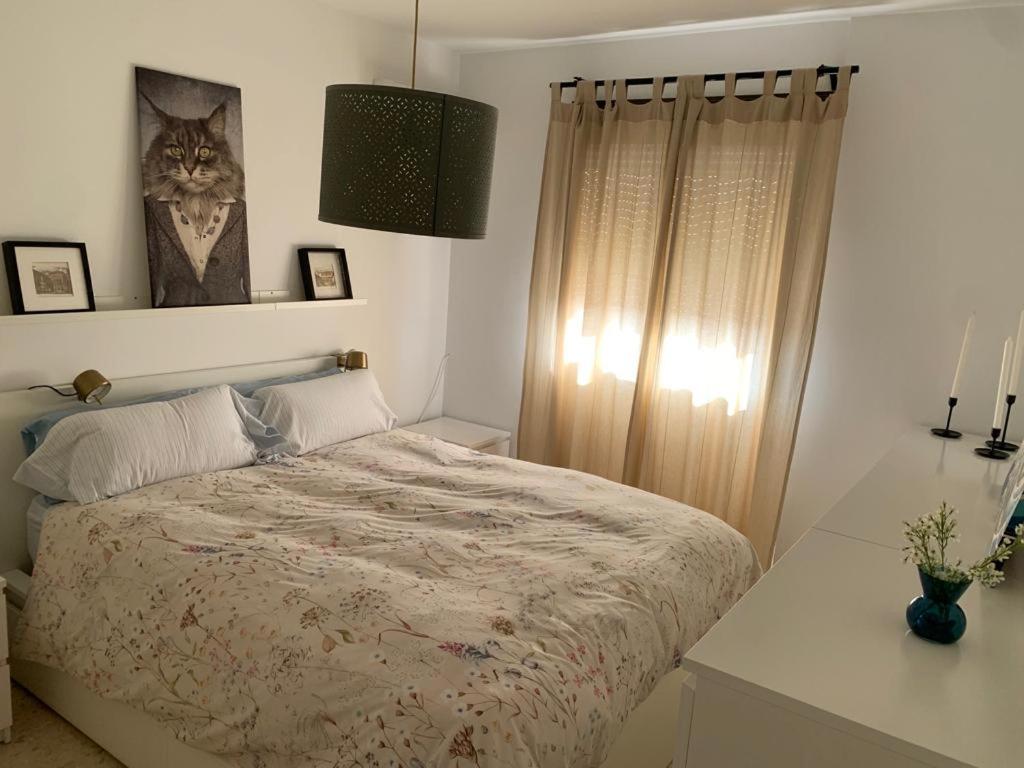 a bedroom with a bed and a cat picture on the wall at Apartamento Al Andalus in Baena