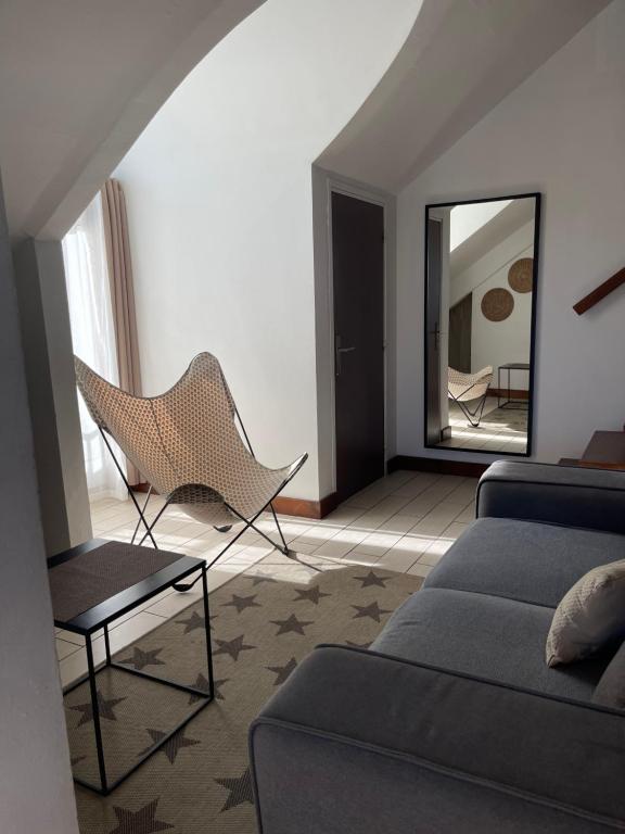 a living room with a couch and a mirror at Duplex Côté Mer in Filaos