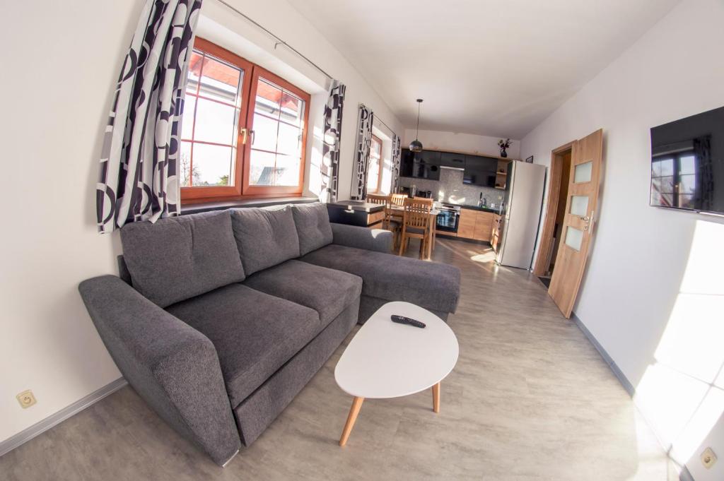 a living room with a couch and a kitchen at Apartmán Benecko 213 in Benecko